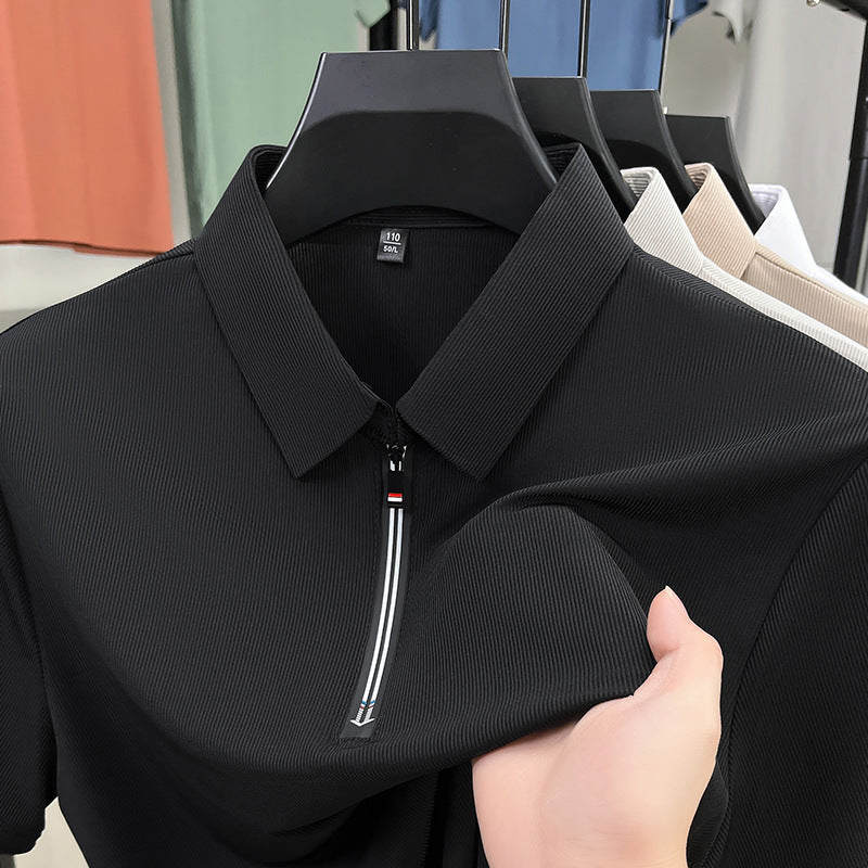 Black polo shirt with a zipper held by a hand in a clothing store.