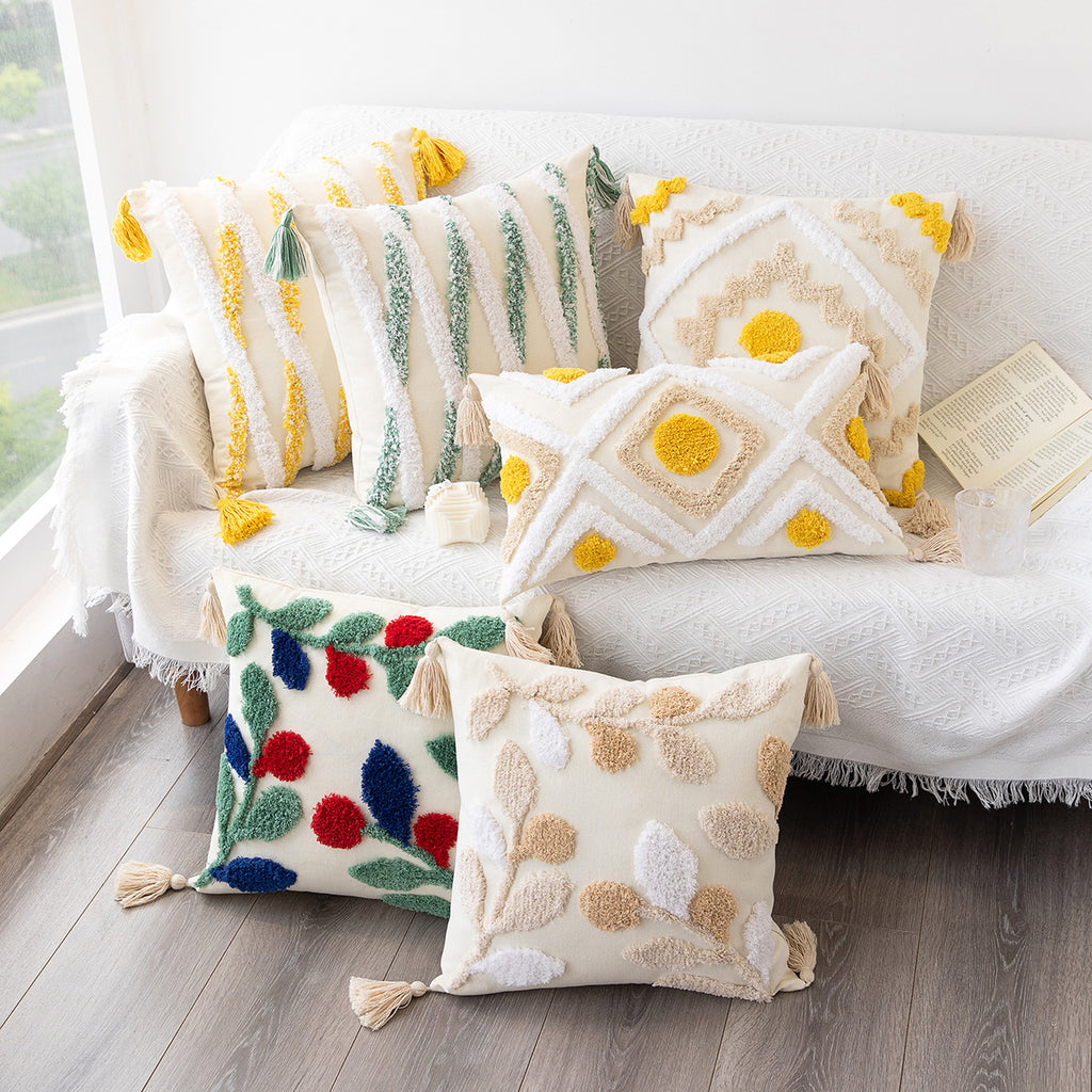 Decorative pillows with colorful patterns on a white couch.
