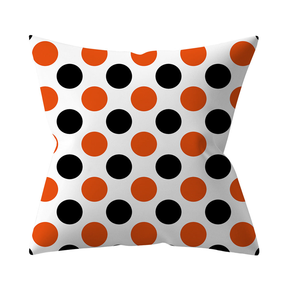 Decorative pillow with orange and black polka dot pattern on a white background