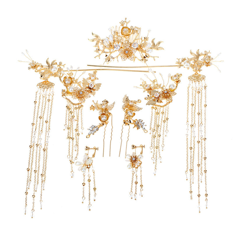 Gold hairpiece with intricate designs and dangling elements on a white background