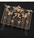 Set of gold and pearl hair accessories on a dark surface