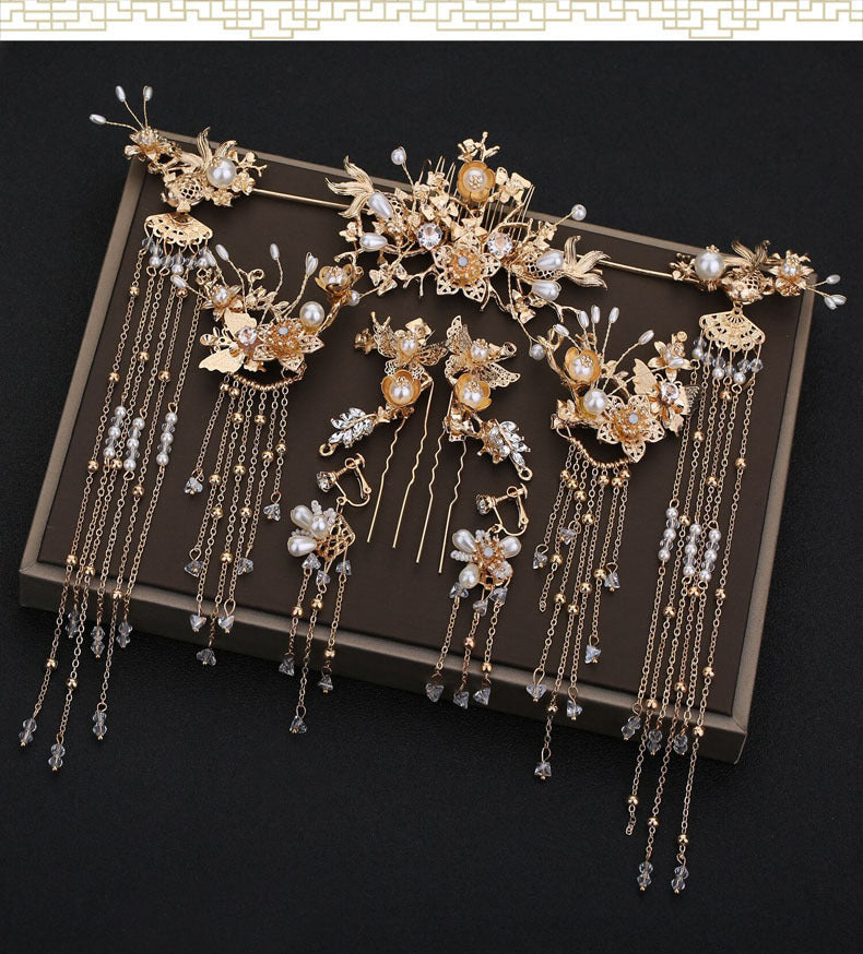 Set of gold and pearl hair accessories on a dark surface