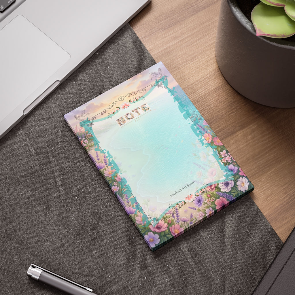 Floral notepad on a desk with a pen and laptop