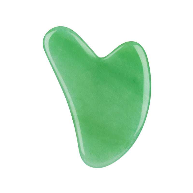 Green jade gua sha tool on a white background