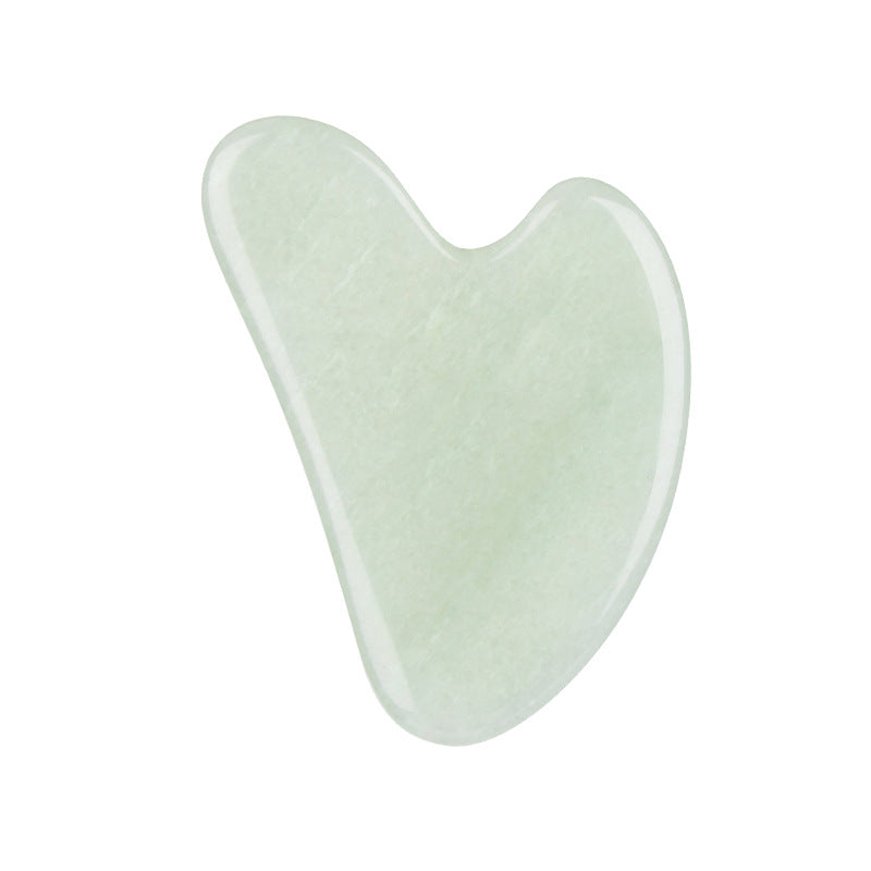 Heart-shaped jade tool on a white background