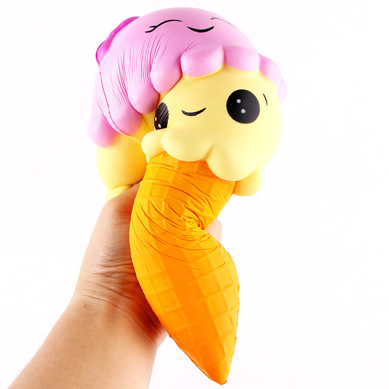 Squishy toy shaped like a yellow ice cream cone with pink hair held in a hand on a white background
