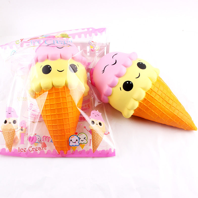 Squishy toy in the shape of an ice cream cone with pink cherry on top, next to its packaging.
