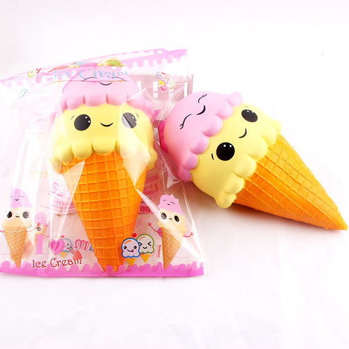 Squishy toy in the shape of an ice cream cone with pink cherry on top, next to its packaging.