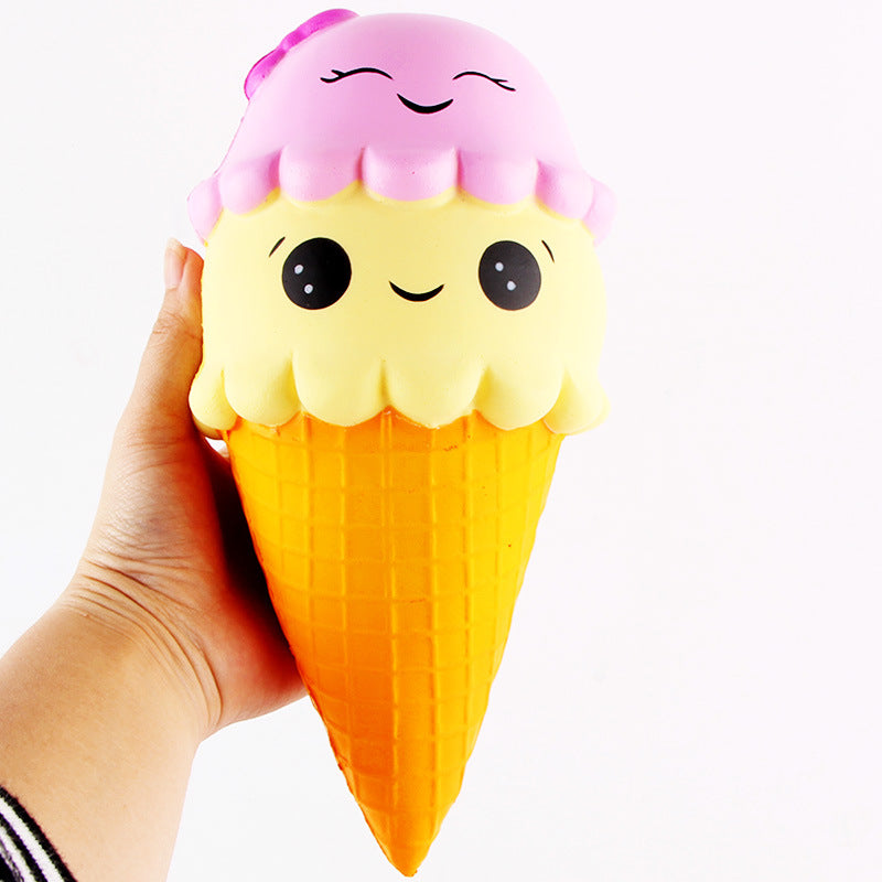 Squishy toy shaped like an ice cream cone with a pink top held by a hand on a white background