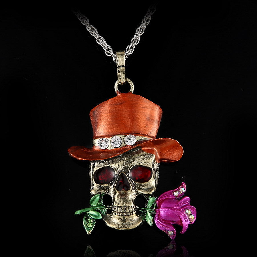 Skull pendant with red top hat and purple flower on a black background