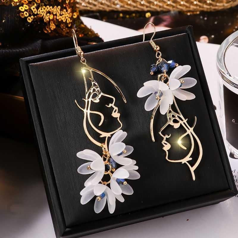 Floral earrings with gold accents on a black display box.