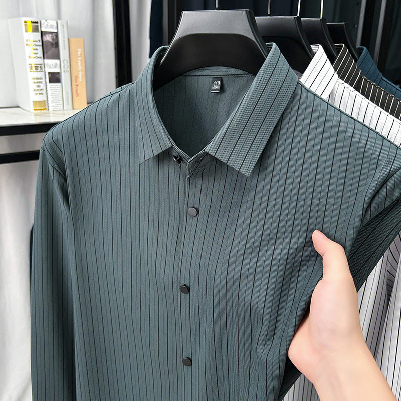 Green ribbed shirt on a hanger with a hand holding it, against a blurred indoor background.