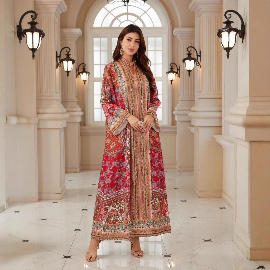 Woman in a patterned dress standing in an elegant hallway with columns and lights.