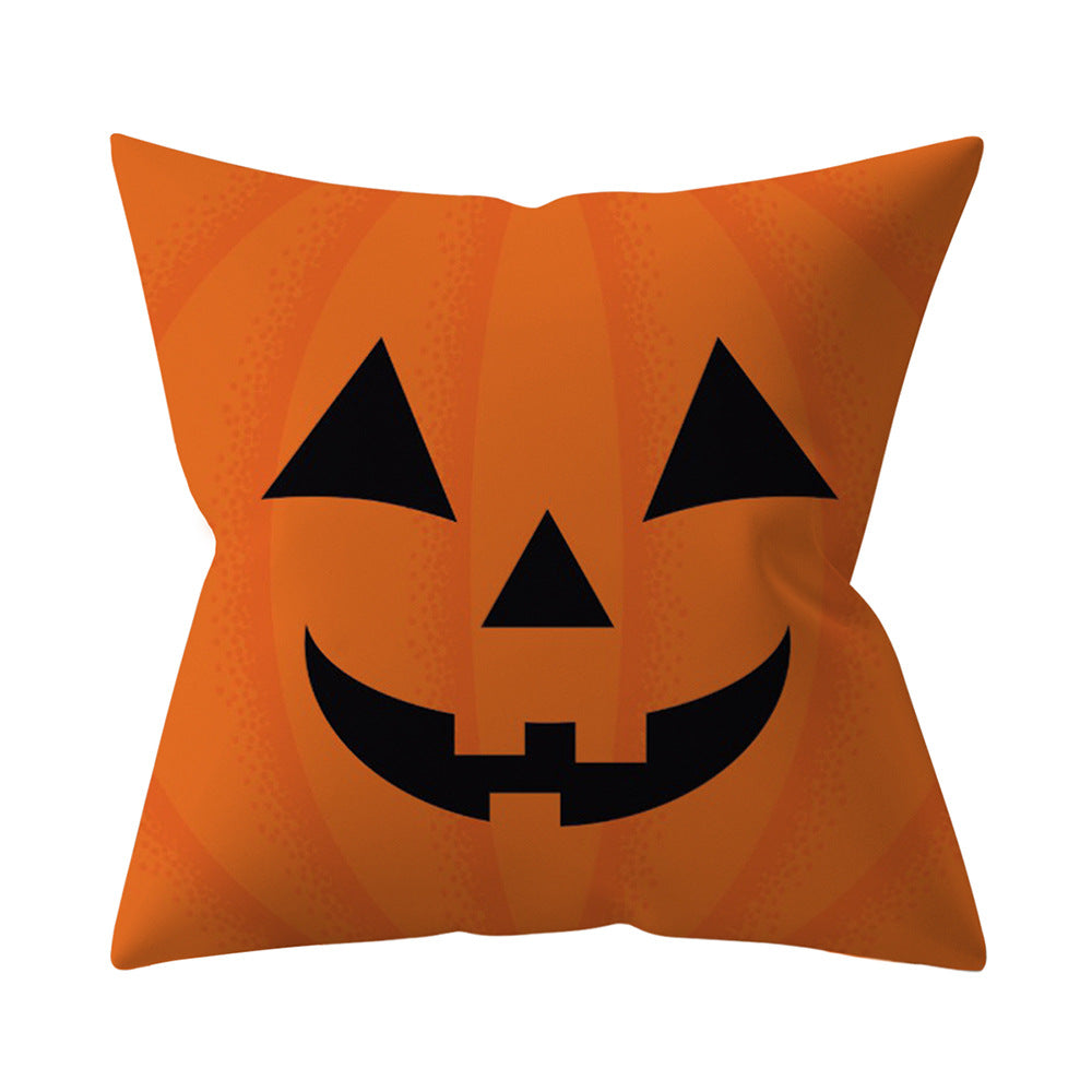 Orange pillow with a black jack-o'-lantern face design on a white background