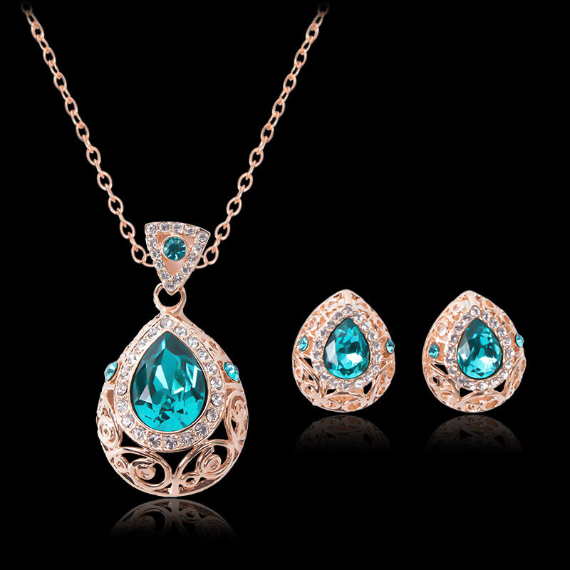 Jewelry set with teardrop-shaped turquoise stones on a black background