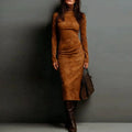 Woman wearing a brown suede dress and boots against a gray background