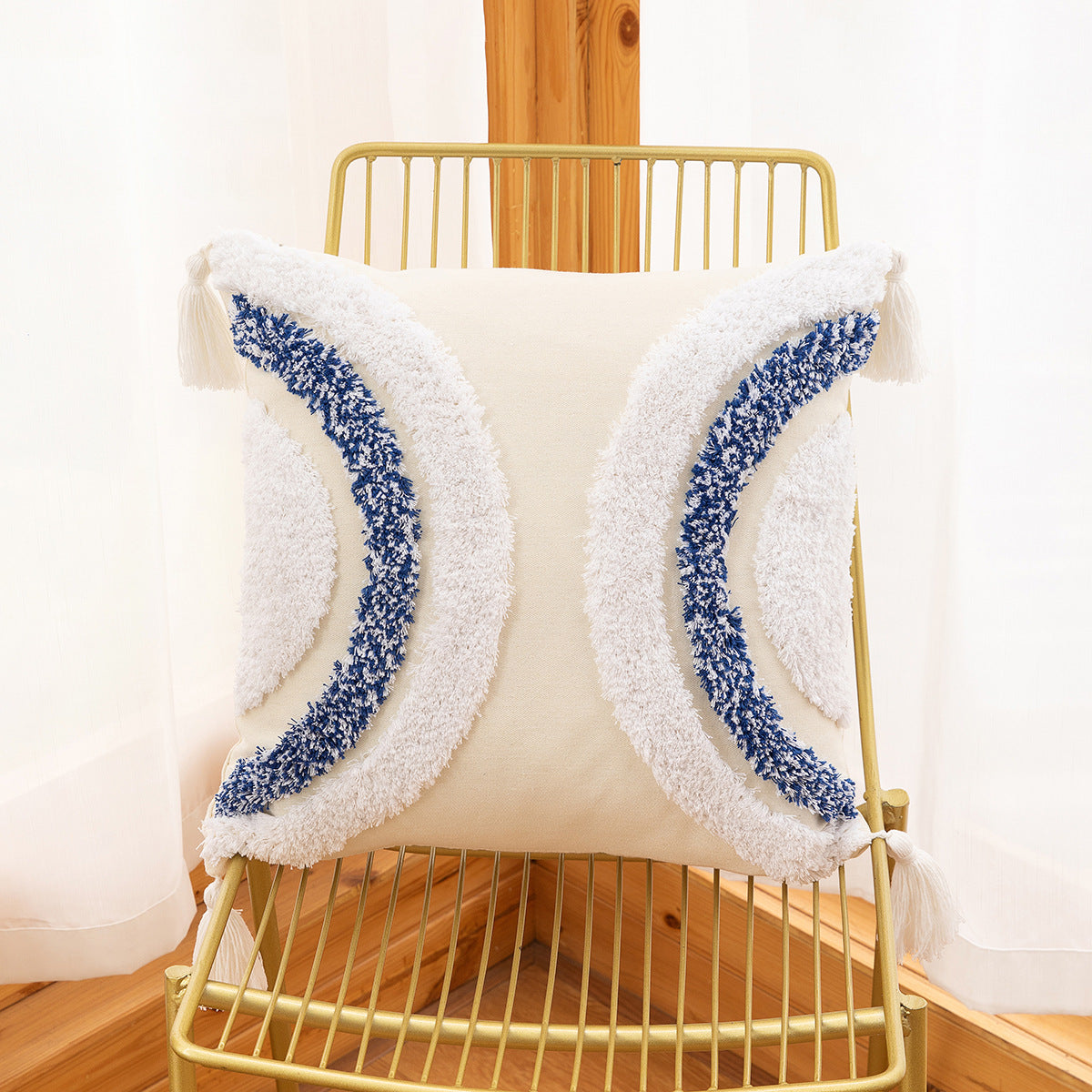 Decorative pillow with blue and white pattern on a gold chair
