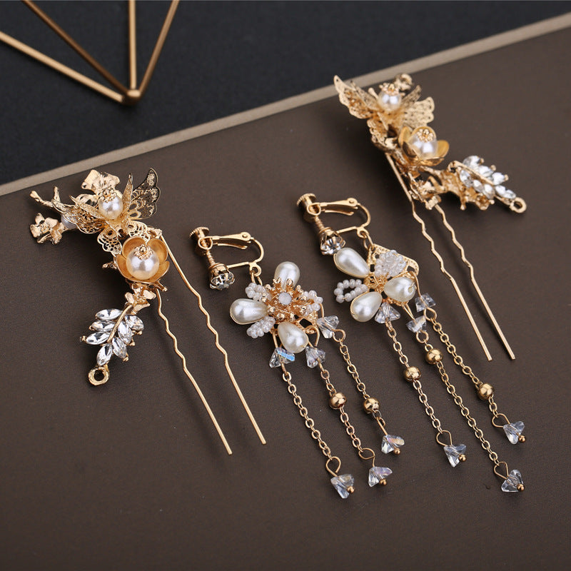Gold hairpins with pearls and crystals on a dark surface
