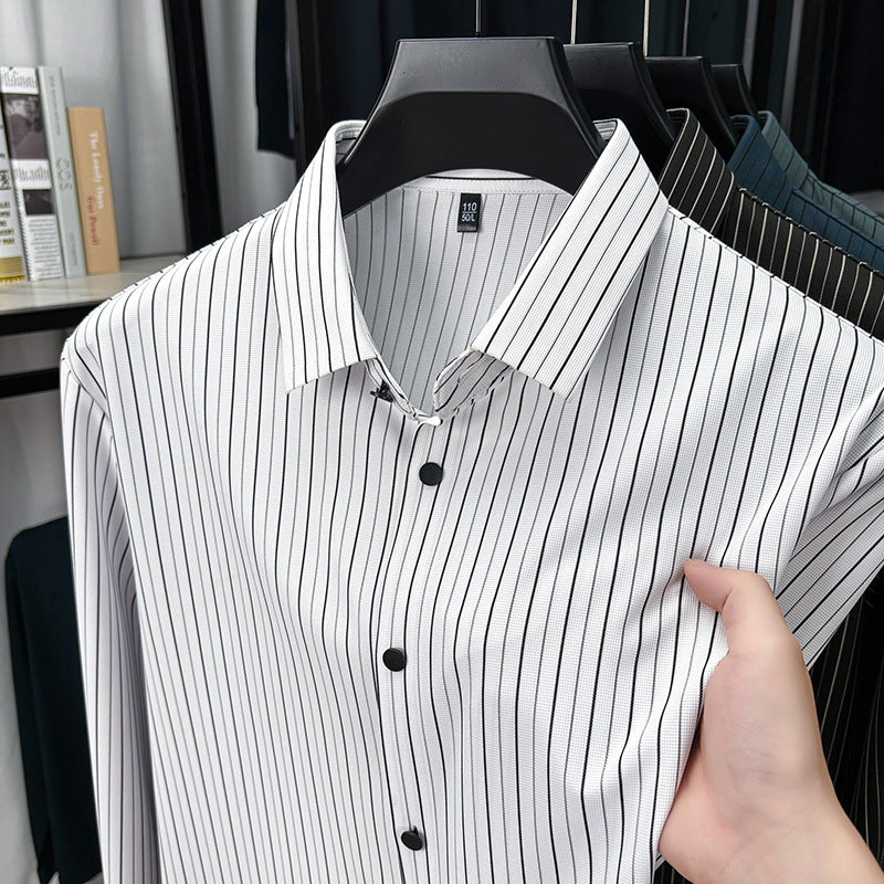 White shirt with black vertical stripes on a hanger, held by a hand.