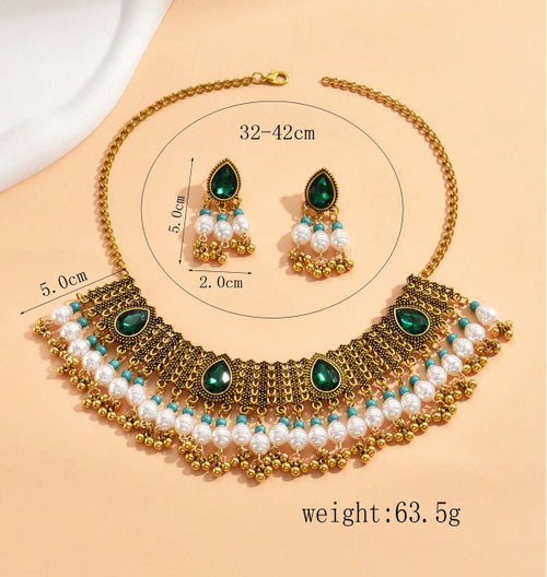 Gold necklace with green and white stones on a beige background