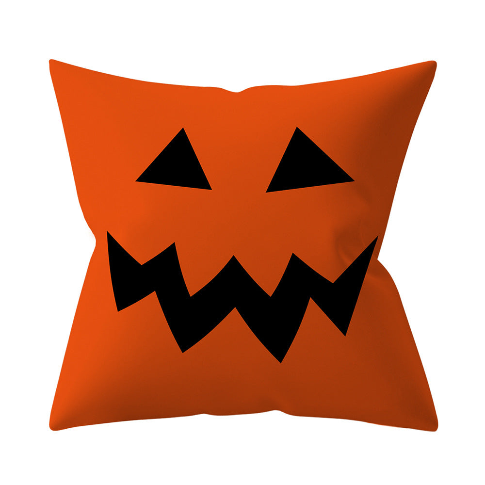 Orange pillow with a black jack-o'-lantern face design on a white background