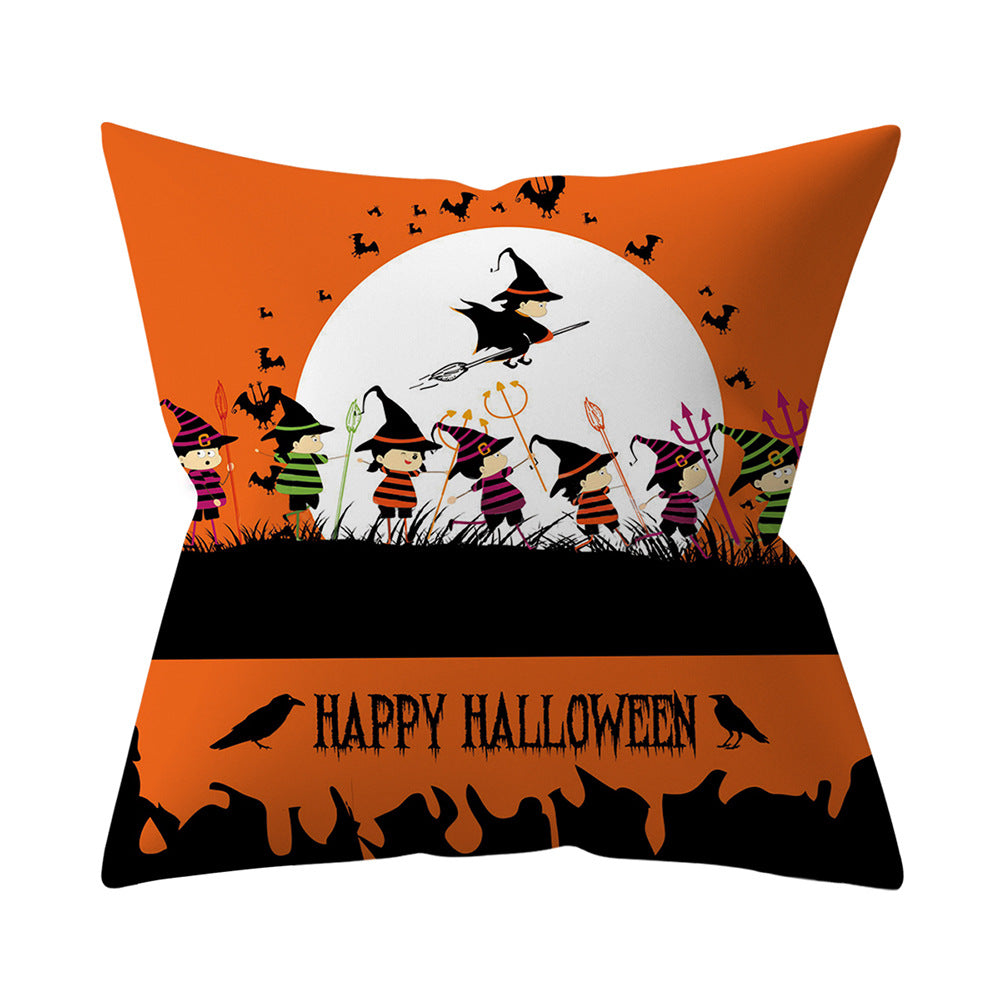Halloween-themed decorative pillow with witches and a full moon on an orange background.