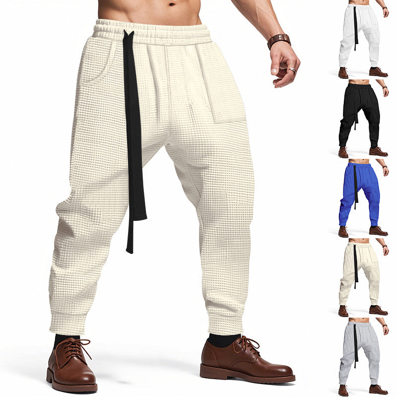 Beige checkered pants with a black strap worn by a person, with multiple color options displayed.