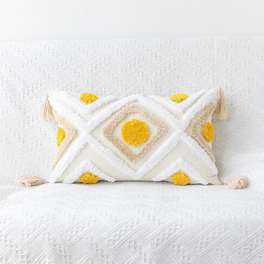 Decorative pillow with geometric pattern and yellow accents on a white textured surface