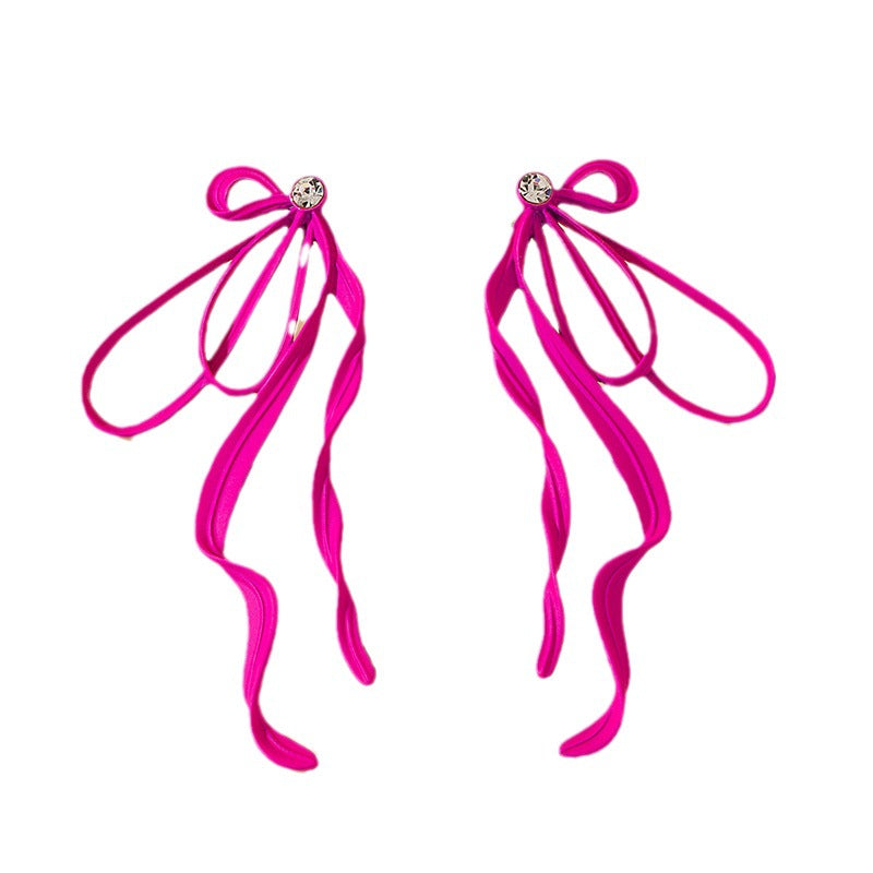 Pair of pink ribbon earrings on a white background