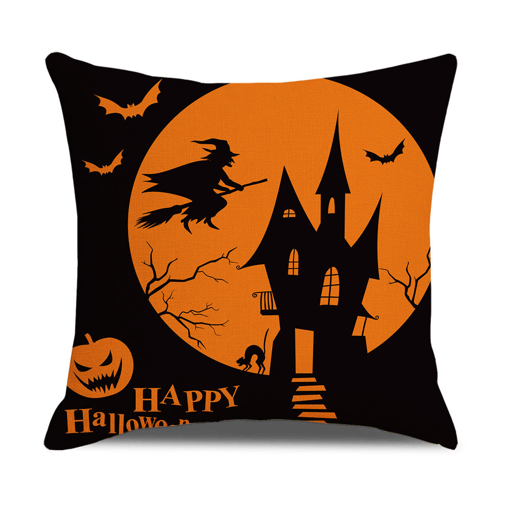 Halloween-themed pillow with a witch flying over a haunted house and pumpkins.