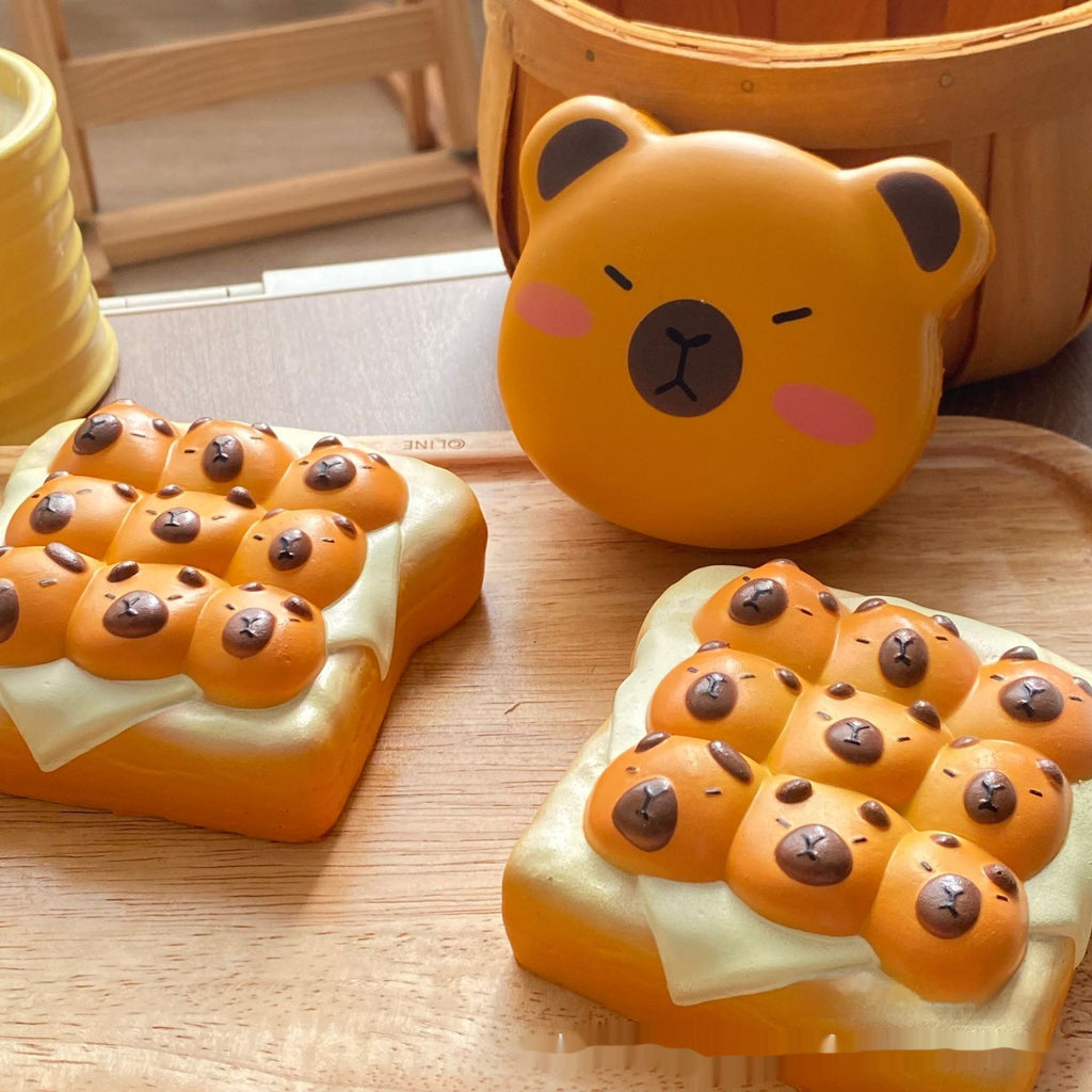 A set of cute, bear-face-shaped food toys styled like mini pancakes or toast, featuring orange bear heads on a pale yellow base, displayed on a wooden tray with a yellow basket in the background.
