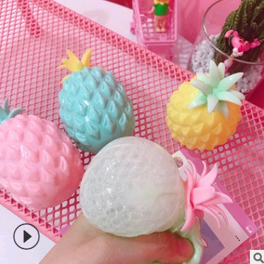Decorative items including a pineapple-shaped squishy toys pink net background.