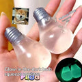 Two translucent squeeze bulb toys held in a person's hand, with text reading 'Glow-in-the-dark bulb squeeze' and a small inset showing a Shiba Inu meme. A circular inset at bottom right shows the bulbs glowing green in the dark.