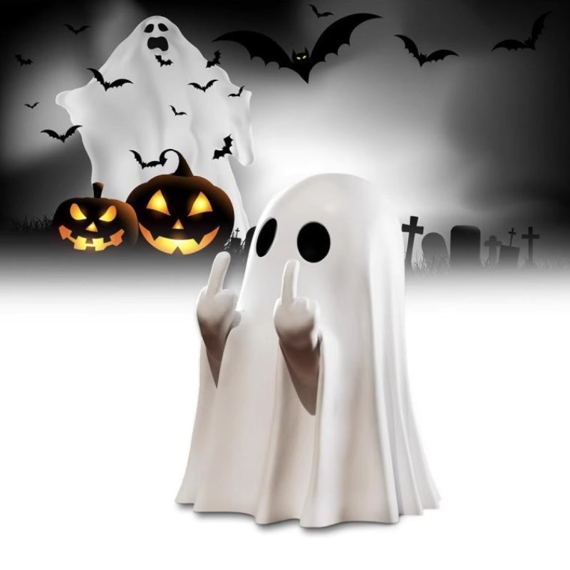 A white ghost costume or ghost-shaped decoration with black circular eyes and raised middle fingers, shown in front of a Halloween scene with black bats, a white sheeted ghost, and two carved jack-o'-lantern pumpkins.