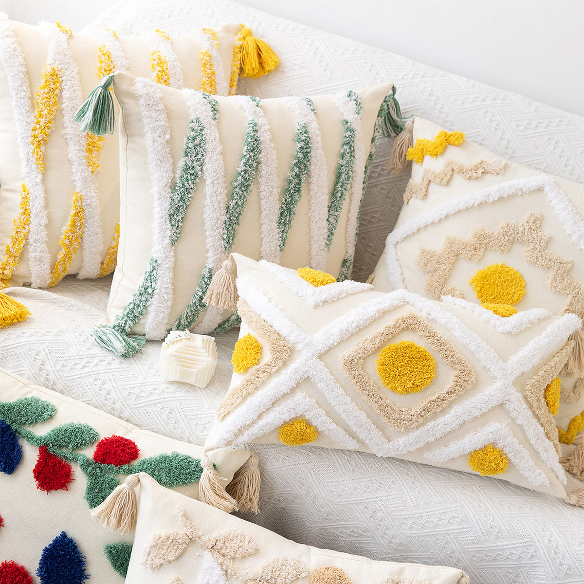 Decorative pillows with colorful patterns and tassels on a white sofa.
