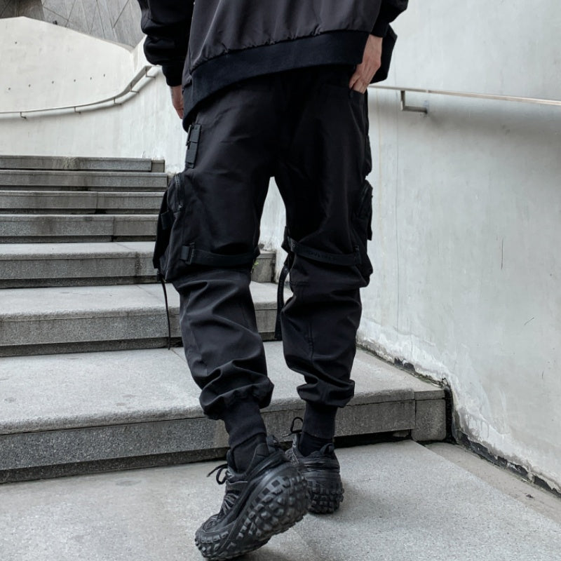 Person wearing black tactical pants and boots standing on a staircase.