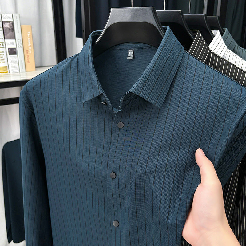 Blue ribbed shirt on a hanger with a hand holding it, in a store setting.