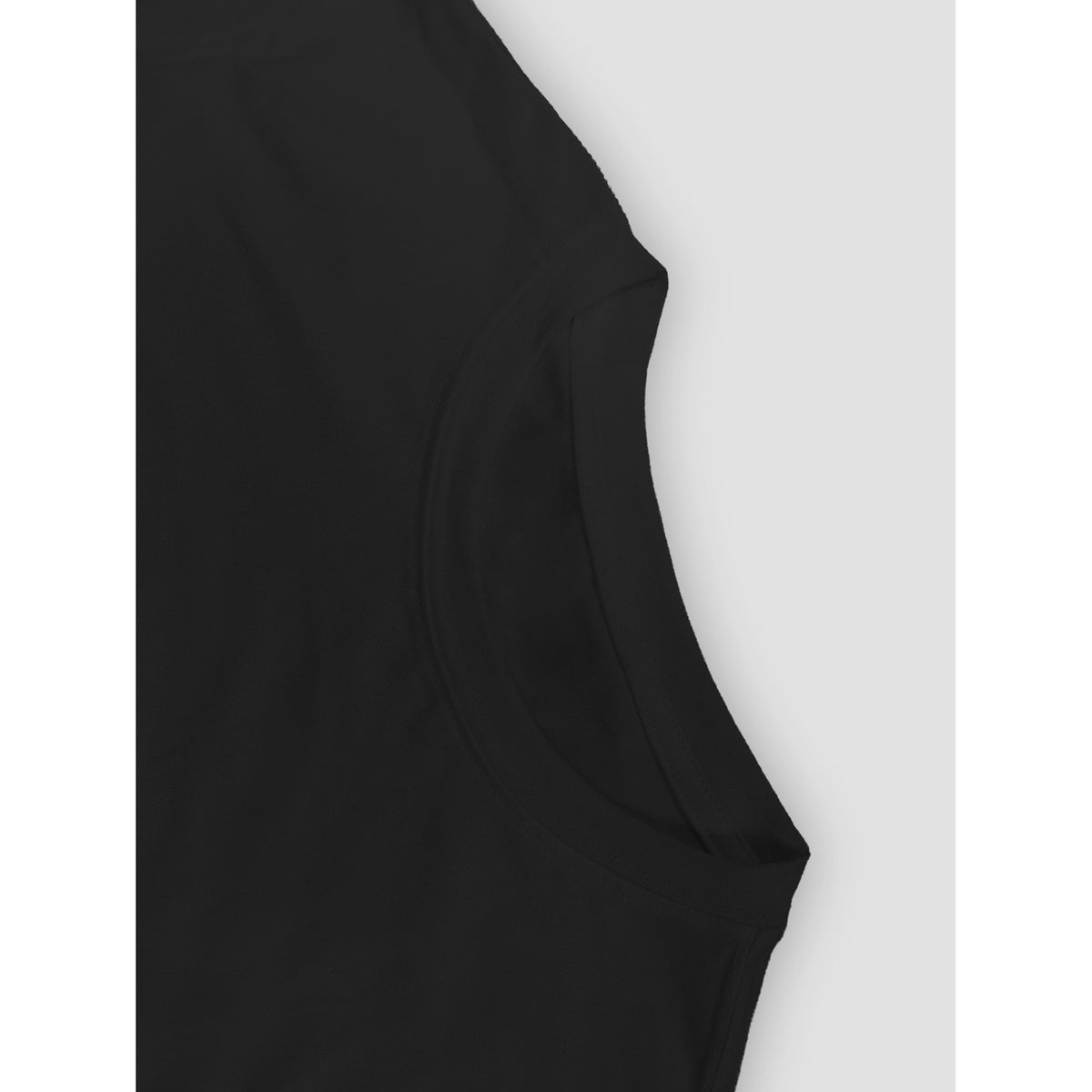 Close-up of a black sleeveless top or dress showing the shoulder and neckline against a light gray background.