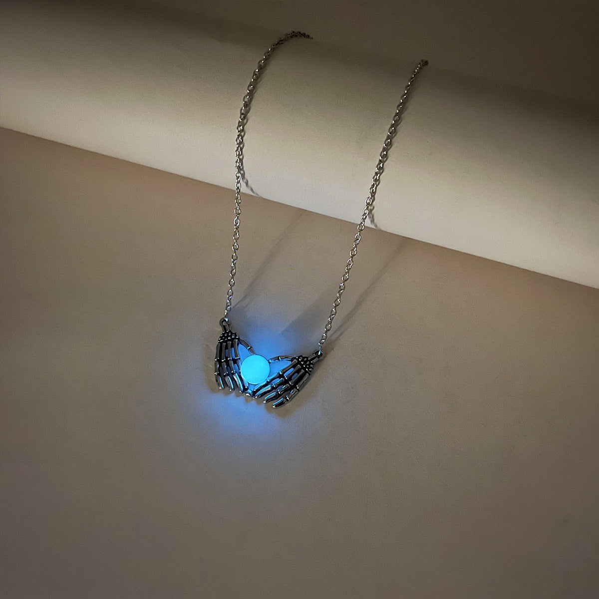 Necklace with a glowing blue pendant on a white surface