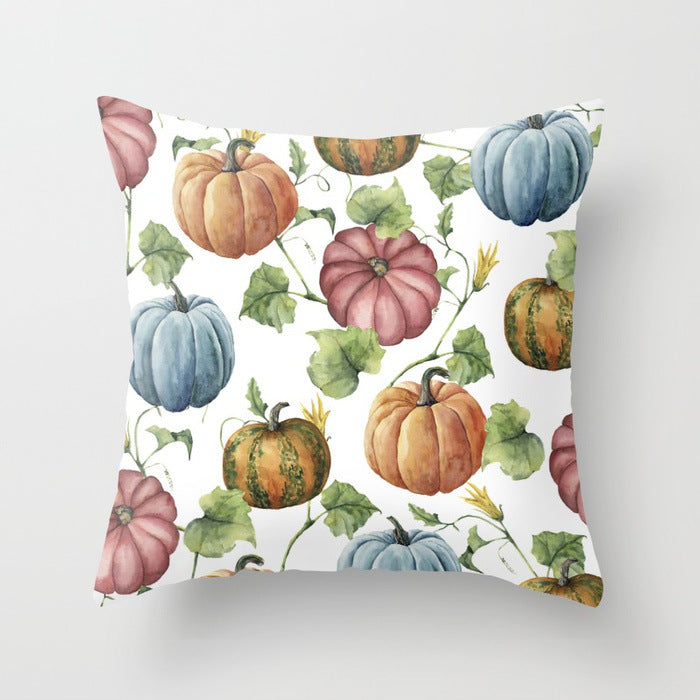Decorative pillow with colorful pumpkins and leaves on a white background