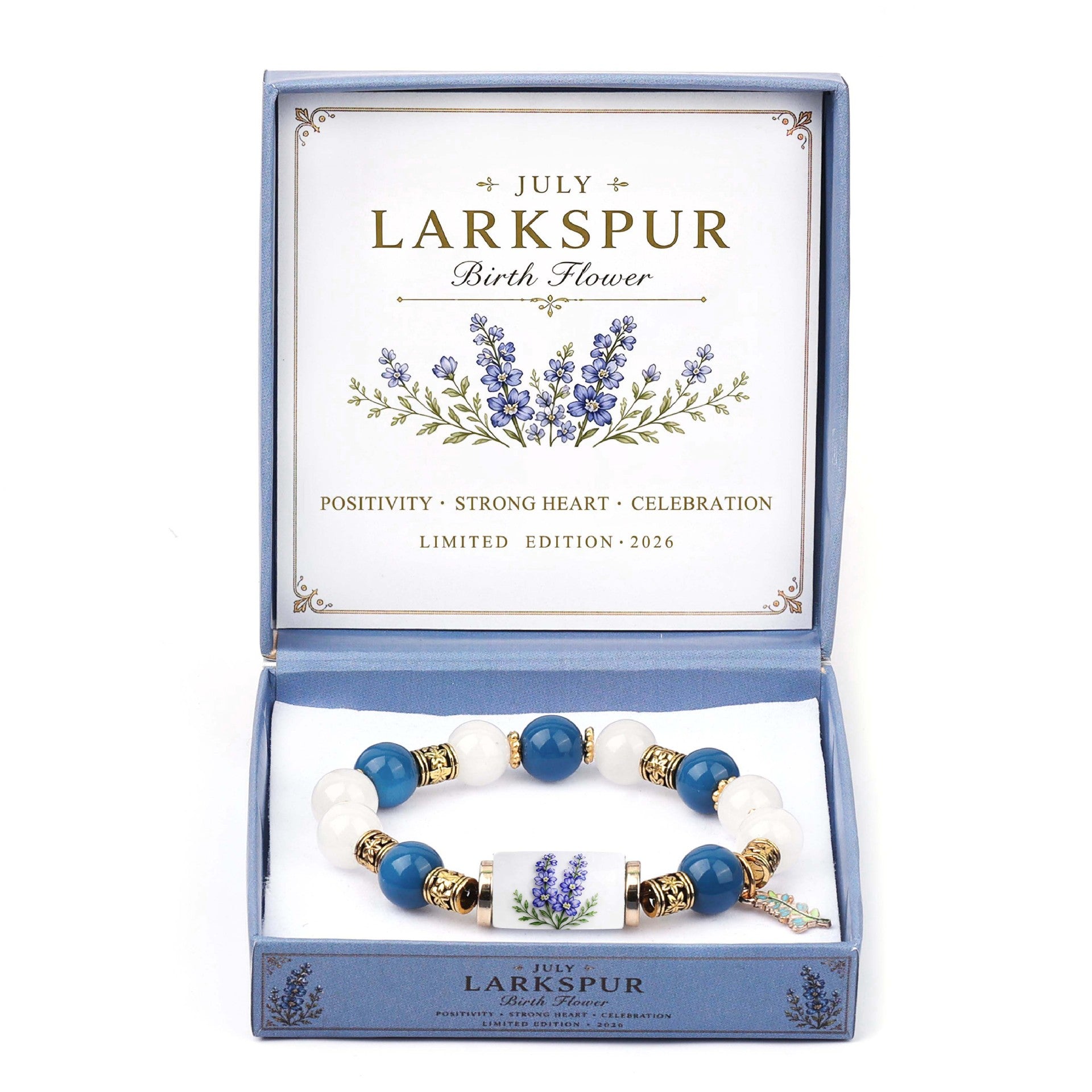 A personalized beaded bracelet presented in an open light blue gift box. The bracelet features blue and white beads with gold spacer accents and a central charm depicting purple lavender flowers.
