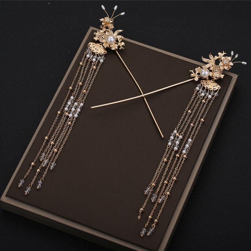 Decorative hairpins with floral designs and pearl-like beads on a dark background