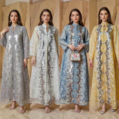Four women wearing long, patterned dresses against a neutral background