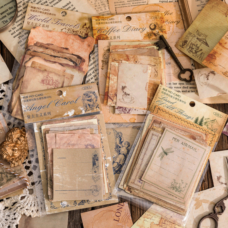 Collection of vintage-style postcards and paper with decorative elements on a textured surface.