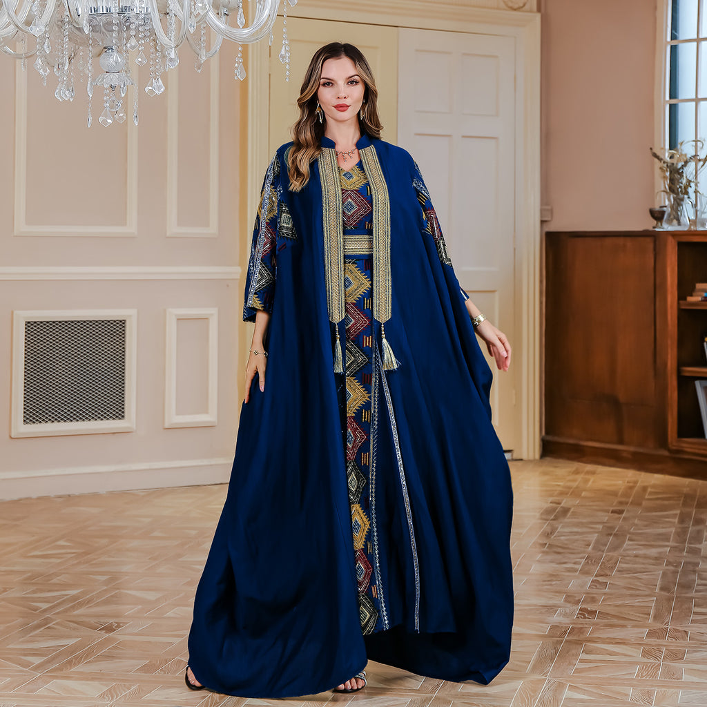 Woman wearing a blue dress with intricate patterns in an elegant room.