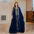 Woman wearing a blue dress with intricate patterns in an elegant room.