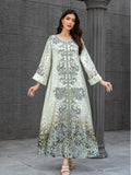 Woman wearing a long, embroidered dress against a gray stone wall.