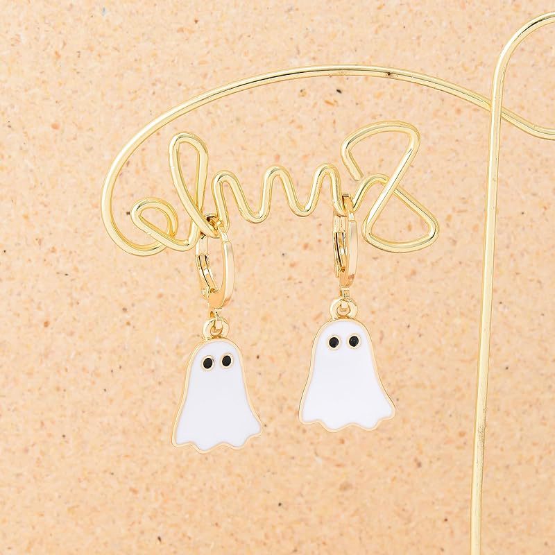 Gold hoop earrings with ghost charms on a beige background