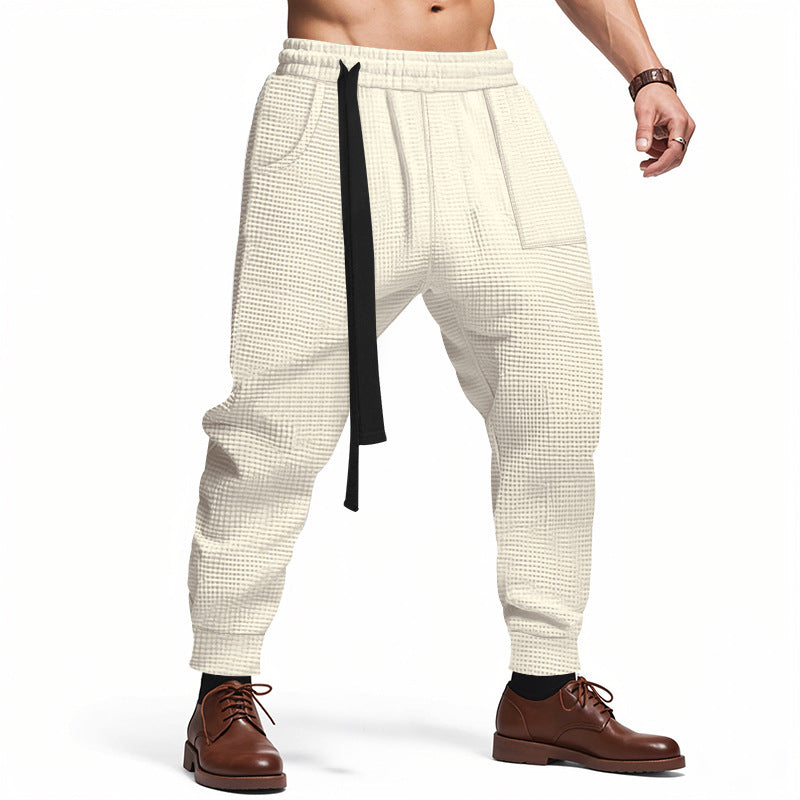 White checkered pants with a black strap worn by a person on a white background