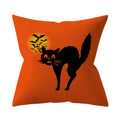 Orange pillow with a black cat and bats design on a white background